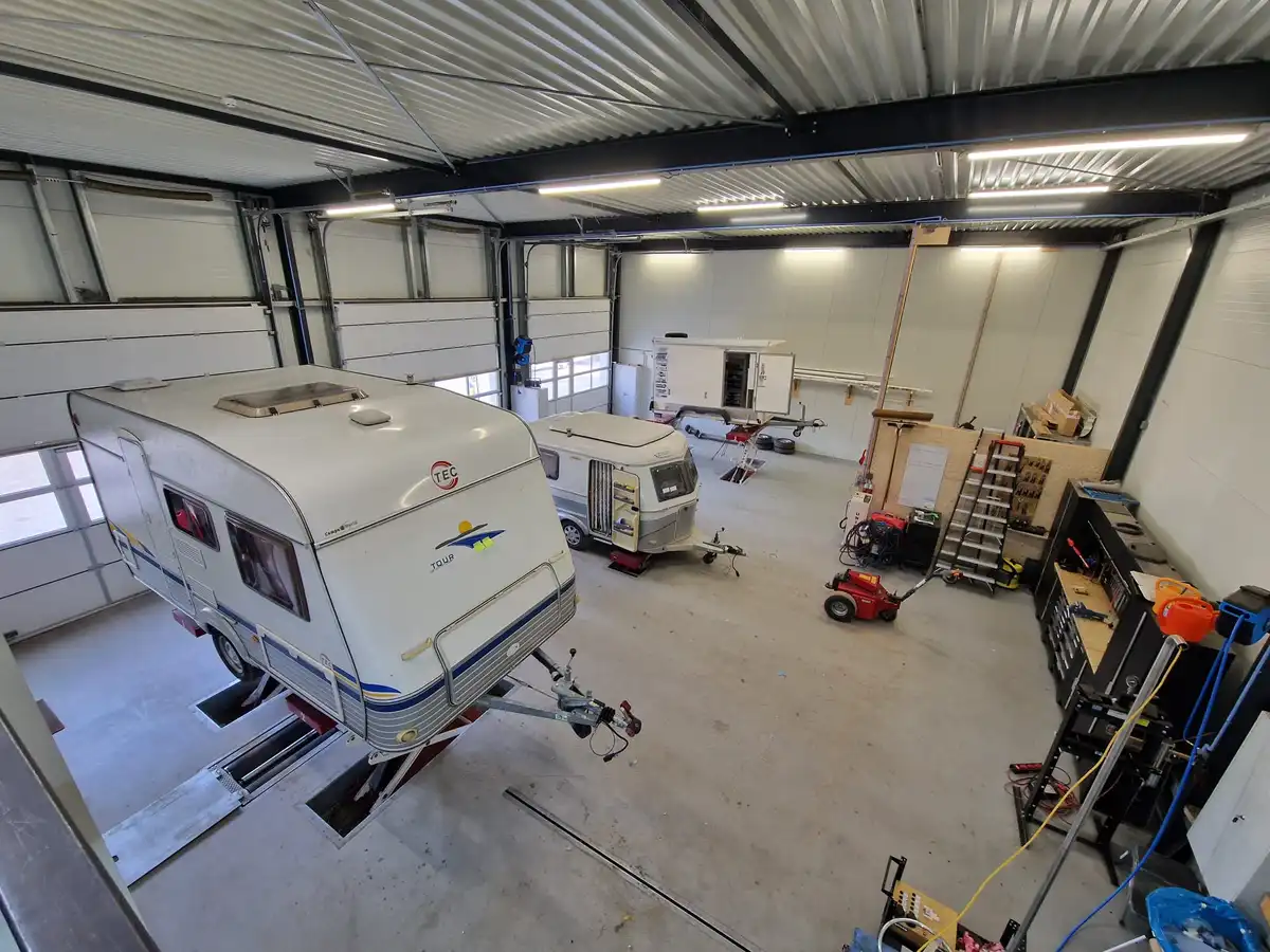 Werkplaats van Caravan Center A20 met twee caravans waar aan gewerkt wordt